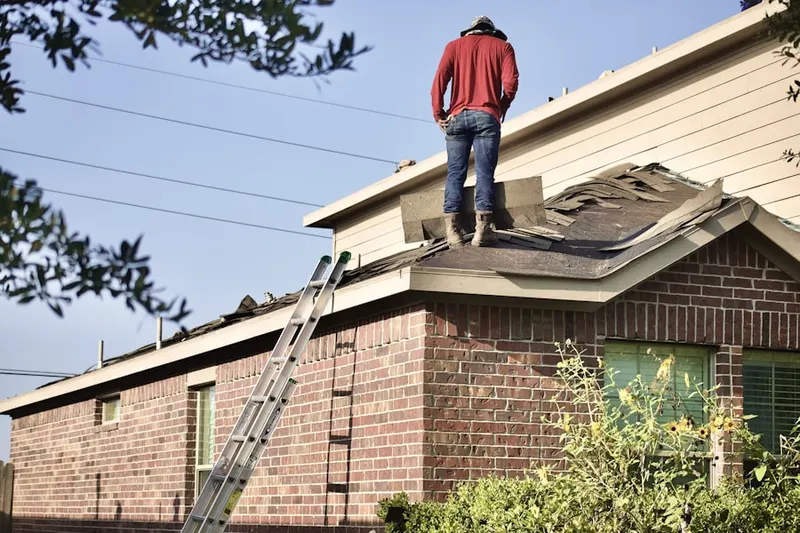 Professional roofer working on a residential roof in Bellerose Terrace